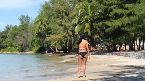 Back View of Young Sexy Asian Woman in Bikini Walking on the Calm Beach Alone