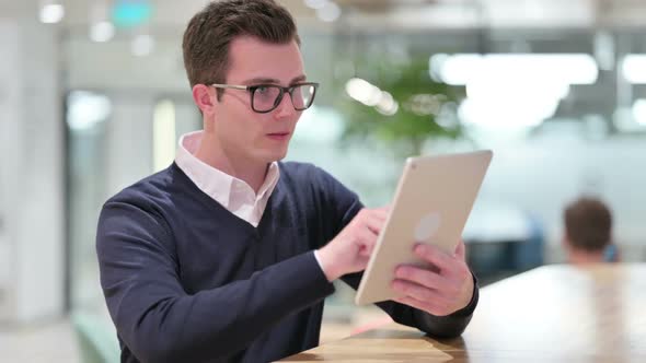 Serious Professional Young Businessman Using Tablet