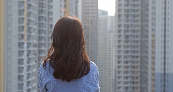 Woman look at the city building in Hong Kong in the evening time