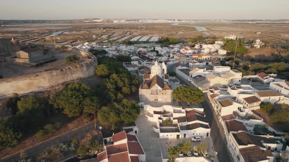 Aerial pull out shot reveals the town square of Church of Our Lady of Martyrs in Castro Marim.