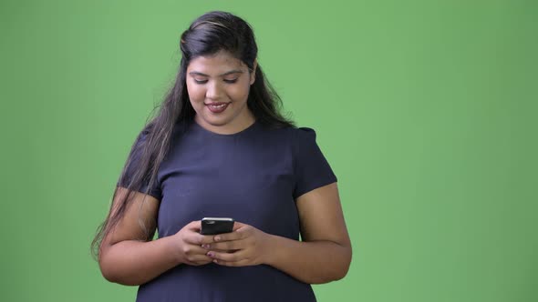 Young Overweight Beautiful Indian Businesswoman Against Green Background