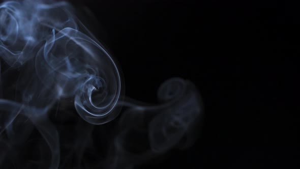 Abstract Smoke Rises Up in Beautiful Swirls on a Black Background