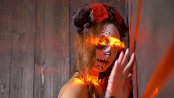 Lady with Skull Makeup Poses with Yellow Light Stripes on Face