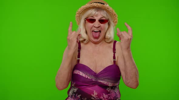 Senior Woman Tourist in Swimsuit Dancing Celebrating Showing Tongue Rock and Roll Hand Gesture