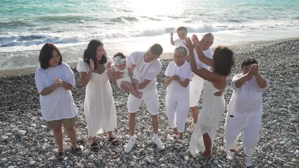 Cheerful Asian Family Clapping Dancing in Slow Motion Laughing with Turquoise Mediterranean Sea