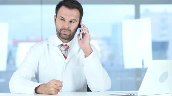 Doctor Talking on Phone with Patient in Hospital