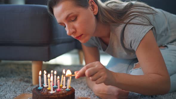 Woman Lighting Candles on Birthday Cake Celebrating Birthday at Home