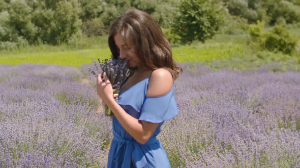 Cute Female Enjoying Fragrant of Lavender Flowers