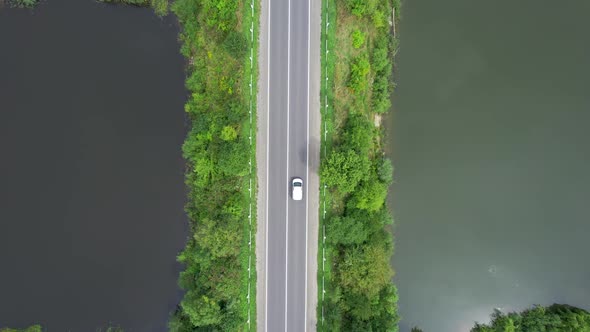 Truck And Car Driving On The Road Through Lakes and Forest Belt