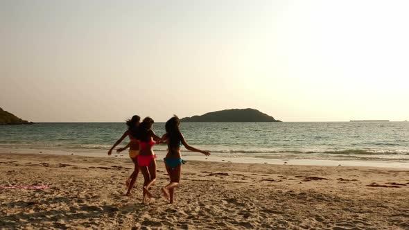 Group of women in bikini walking and having fun on the beach