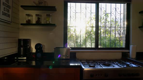 Cinematic Indoors Shot of a Kitchen Panning Through Window Revealing a Sunny Day