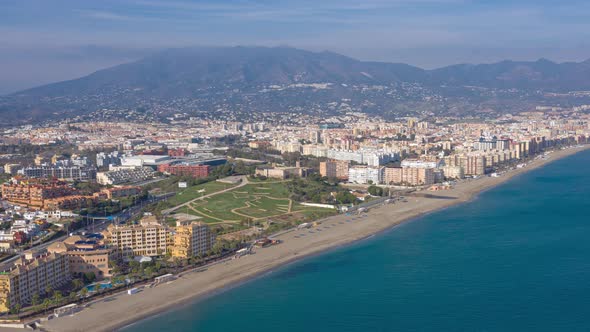 Aerial drone hyperlapse timelapse of  Fuengirola in Spain and the beachfront from over the sea looki alt