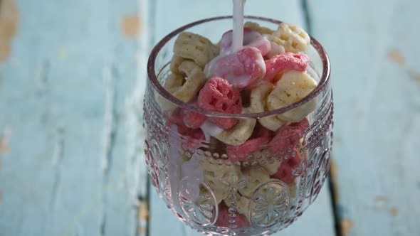 Milk being pour into glass of honeycomb cereal