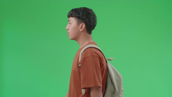 The Side View Of Asian Boy Student With His Backpack Walking To School On Green Screen Chroma Key
