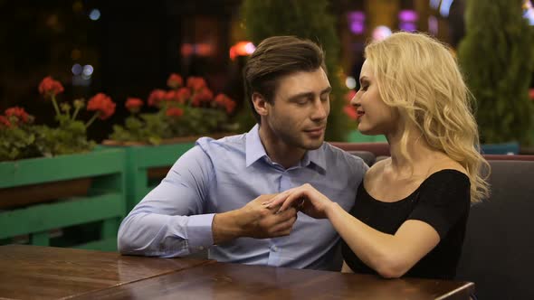 Amorous Admirer Kissing Hand of His Beautiful Lady, Sitting in Cozy Restaurant