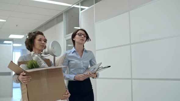 Young Female Coworkers Bringing Belongings to New Office