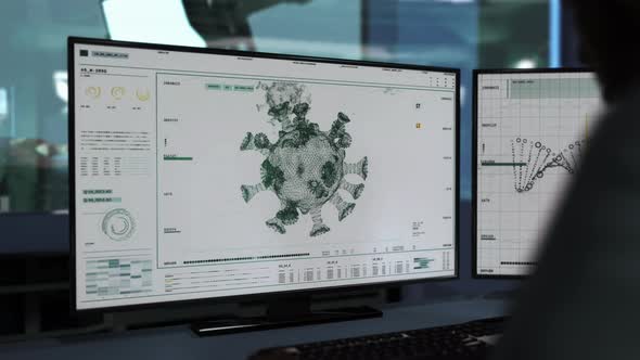 A doctor is sitting behind two monitors. Coronavirus was found. User Interface. alt