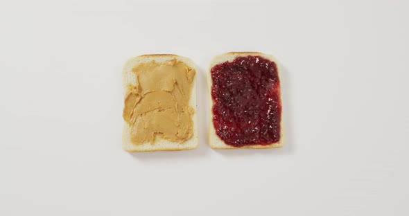 Close up view of peanut butter and jelly sandwich with copy space on white surface