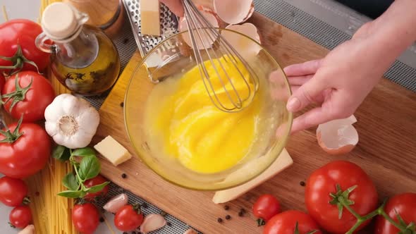 Making Pasta Carbonara  Mixing Egg Yolks in Glass Bowl By a Whisk