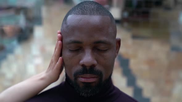 Black Man Is Standing with Closed Eyes and Hands of White Woman Are Stroking His Head