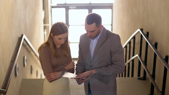 Businesswoman and Businessman Discussing Folder 16