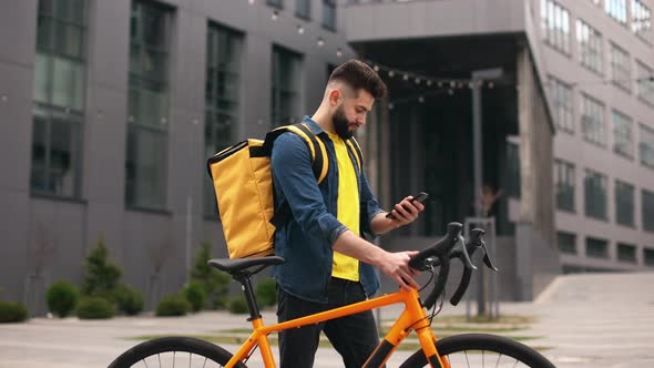 The Food Delivery Guy is Standing and Texting