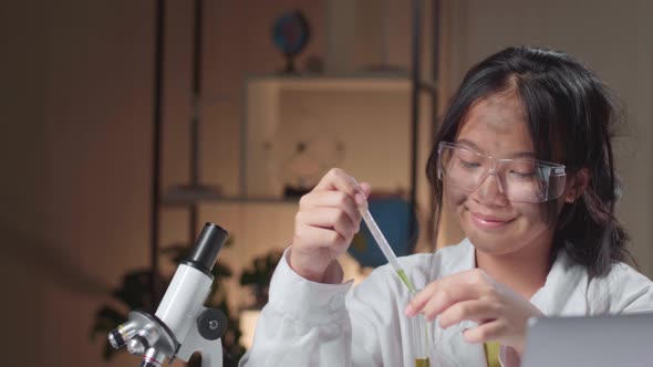 Young Asian Scientist Girl With Dirty Face Mixes Chemicals In Test Tube. Child Learn With Interest