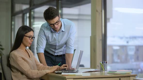 Man Helping to His Female Colleague Fill in Application