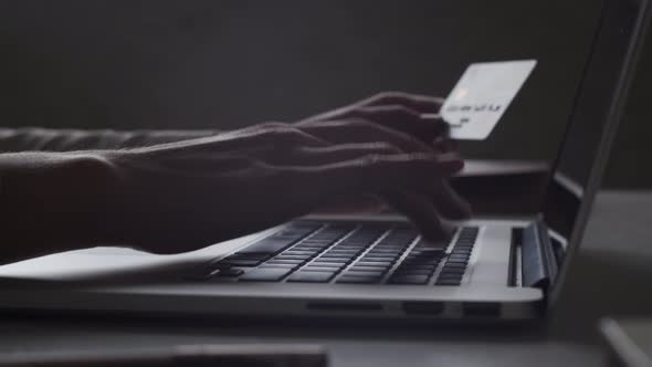 Closeup hands entering credit card data typing on laptop keyboard. Online banking, Internet shopping