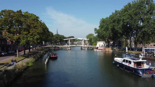 A pleasure boat sails up the Vecht towards a bridge at Weesp in Netherlands