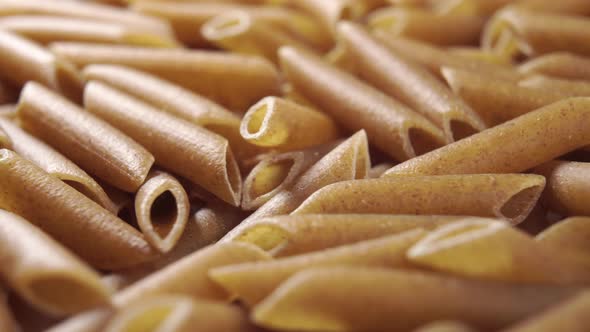 Raw italian pasta penne integral rotates