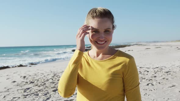 Woman standing on the beach and looking at camera