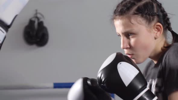 Young Sporty Girl Gets Rapid Punches with Boxing Gloves. Slow Motion