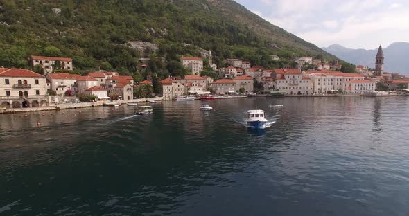 Motor Boats Sail Past the Coast of Perast