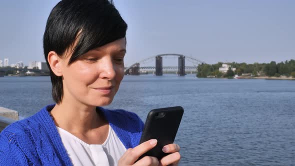 Casual Girl Texting Message on the River Bank