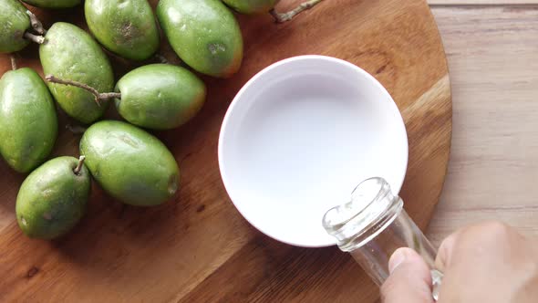 Bottle of Olive Oil and Fresh Olive in a Container on Table