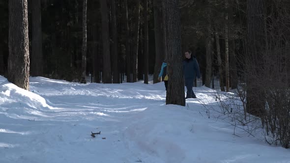 A Couple in Love Walks Through the Winter Forest and Holds Hands