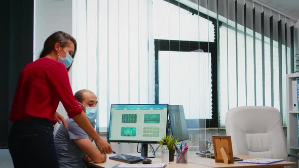 Colleagues with Masks Discussing Graphics