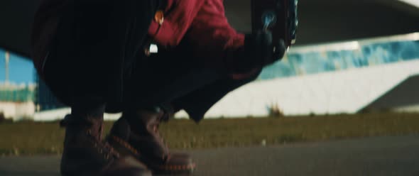 Young man grabbing vintage camera from the ground to get ready to use it