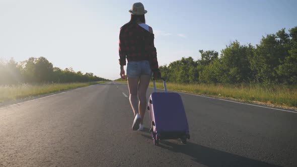 Traveler Woman with Suitcase on Road To Travel. Concept of Travel.