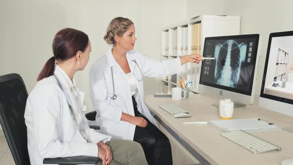 Female Doctors Discussing Chest X Ray on Computer