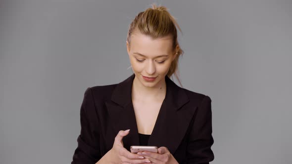 Stylish Businesswoman Browsing Smartphone in Studio