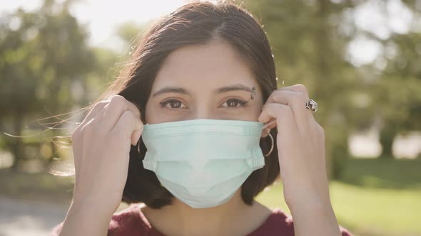 Beautiful woman putting off her surgical mask