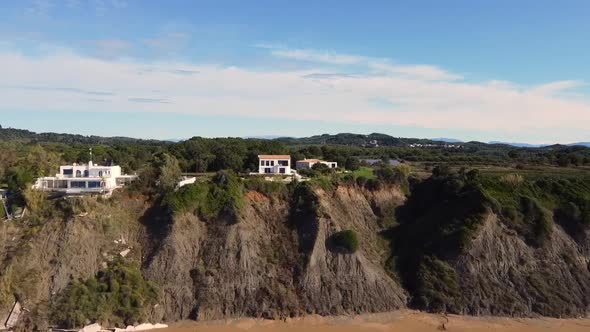 Breathtaking daytime aerial drone flight offshore coastline waves to a luxury villa on a malibu clif