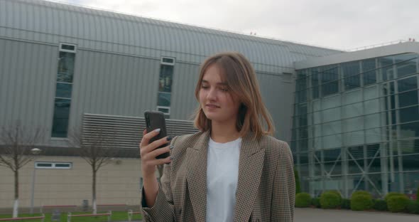 A Young Girl Is Texting a Message and Smiling. Travel By Plane. Sunny Weather. 