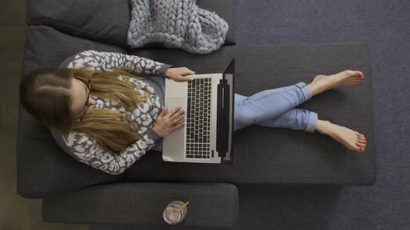 Top View Female Freelancer with Laptop on Sofa