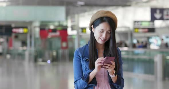 Woman search on mobile phone in the station