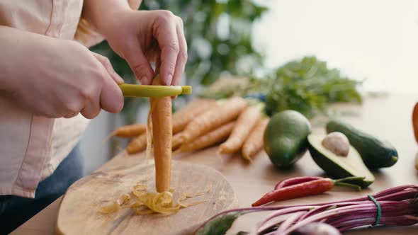 Close up of woman's hands peeling carrots