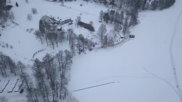 Overhead shot of picturesque rural community dressed in a beautiful winter coat on the edge of big f