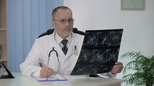 Neurologist Checking Angiography of Blood Vessels, Making Description in Cards